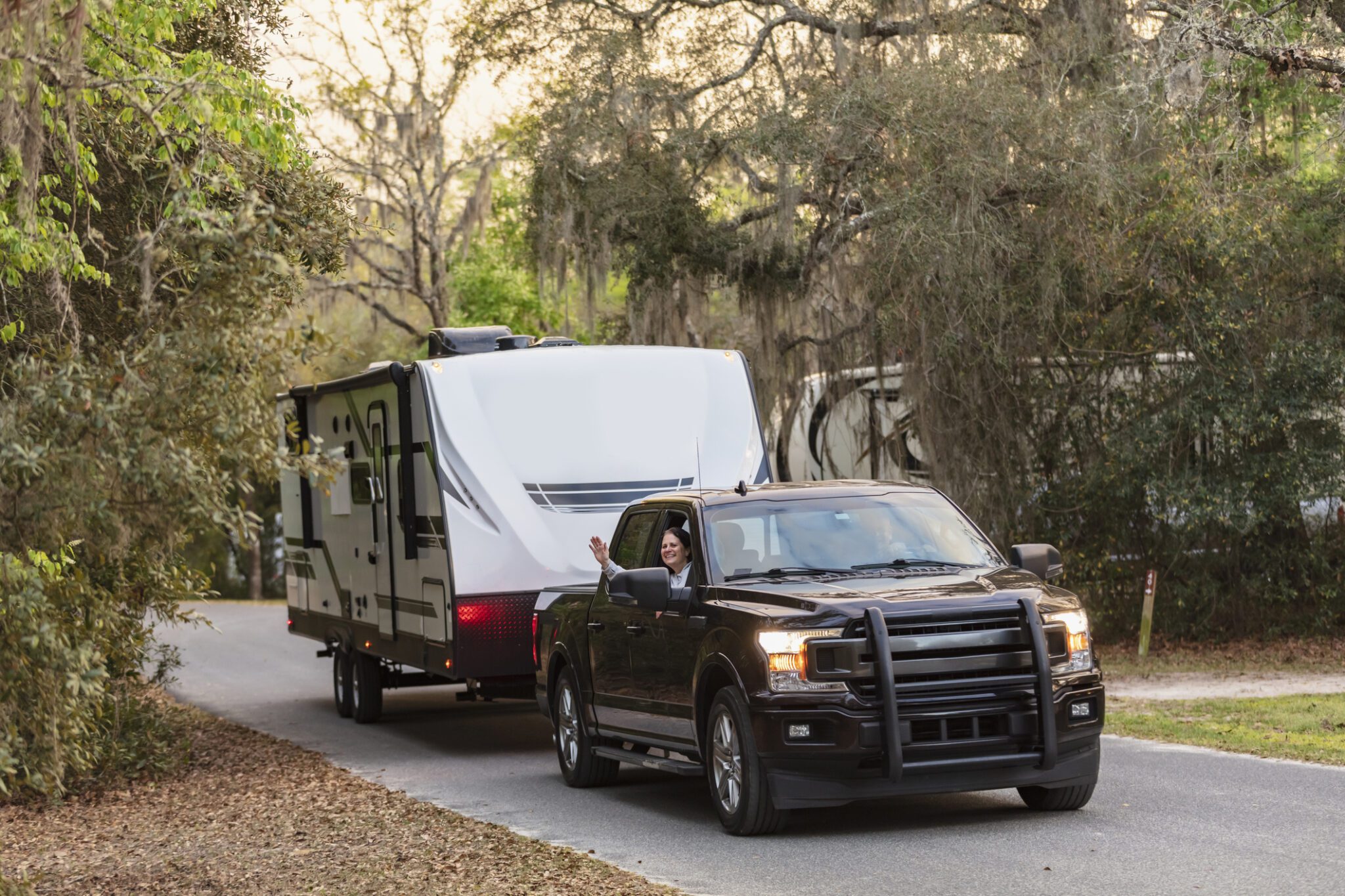 Truck towing a camper trailer on road