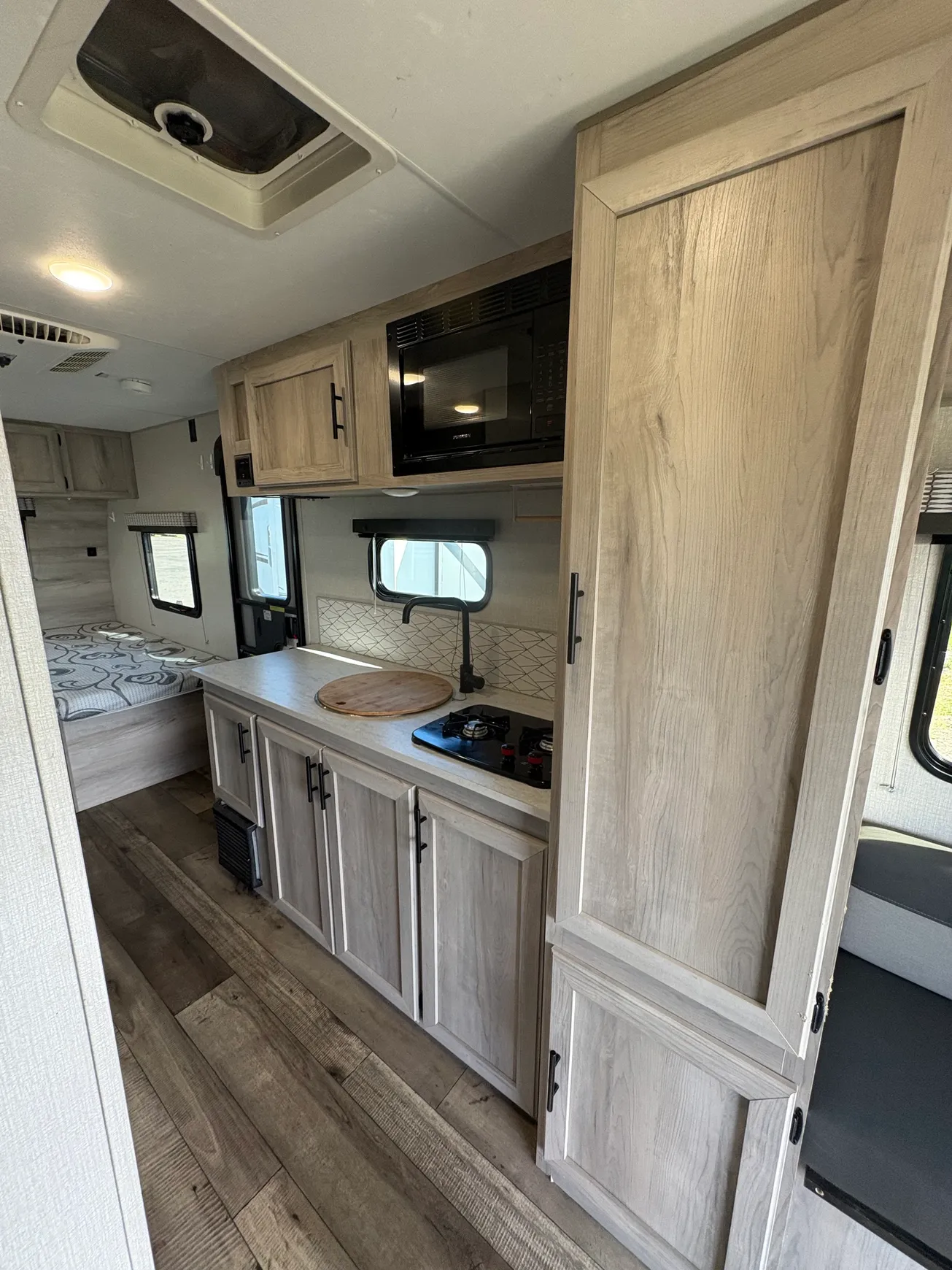 Compact RV kitchen interior with wood cabinets