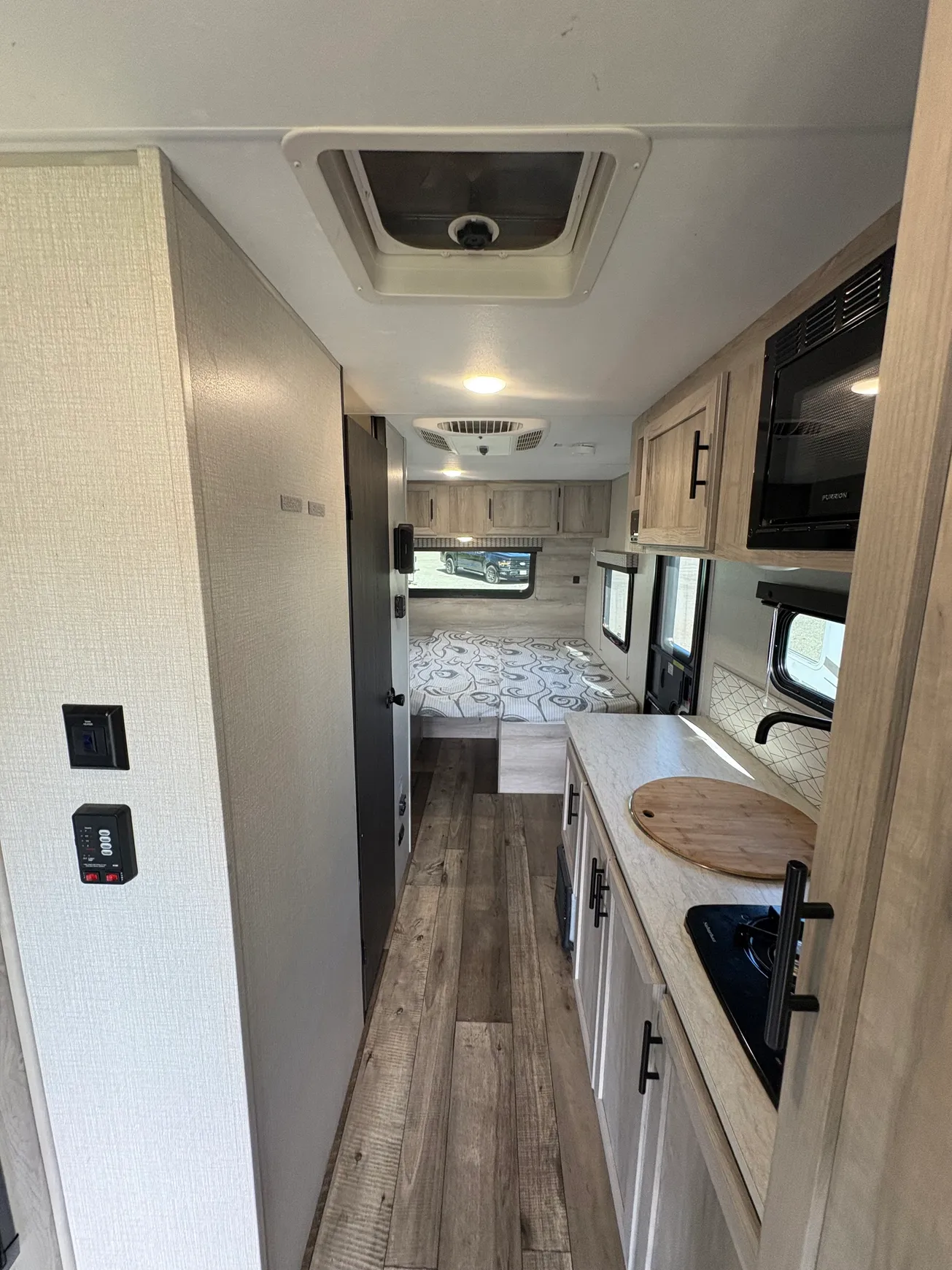 Compact RV interior with kitchenette and bed